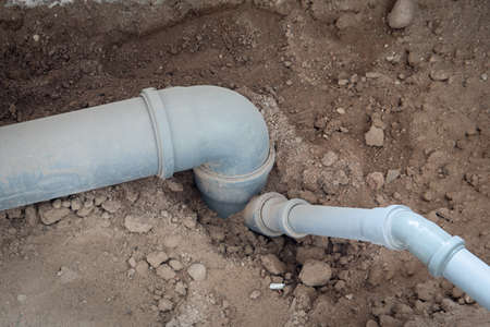 Gray sewer pipes. Inside the building, buried in the ground