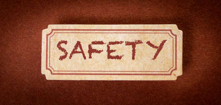SAFETY. Text on cardboard and brown textured background