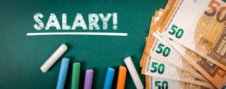 Salary. Euro money and colored pieces of chalk on a green boardの写真素材