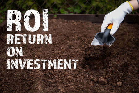 ROI Return on investment. Diging the soil with a garden shovelの写真素材