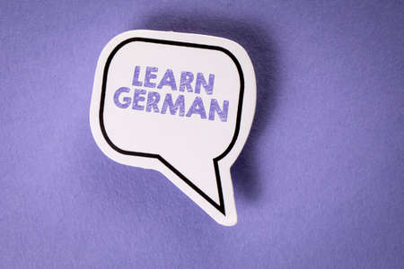 Learn German. White speech bubble on a purple backgroundの写真素材
