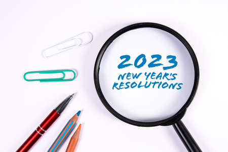 2023 New Years Resolutions. Magnifying glass on a white background