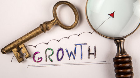 Growth concept. Magnifying glass and door key on white backgroundの写真素材