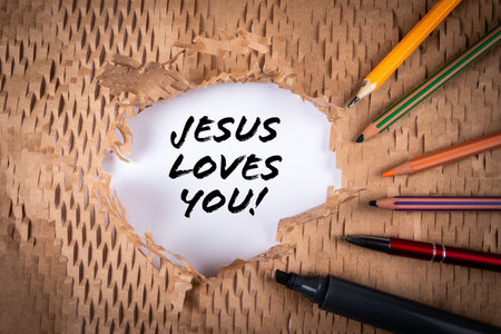 Jesus Loves You. Text and stationery on cardboard backgroundの写真素材