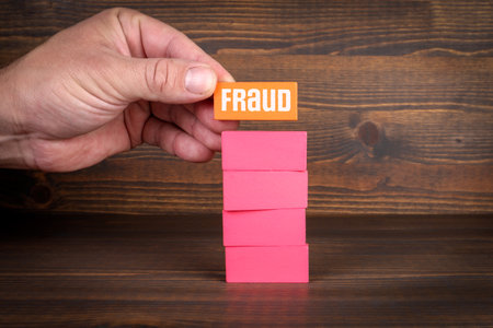 Fraud concept. Colorful wooden blocks in a pile on a textured backgroundの写真素材
