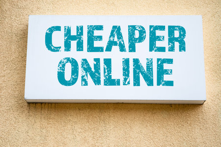 Cheaper Online. Advertising sign on the wall of a yellow building