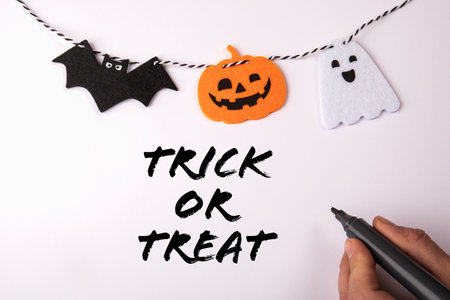 Trick or treat. Hand with a black marker on a white background. Halloween decorationsの写真素材