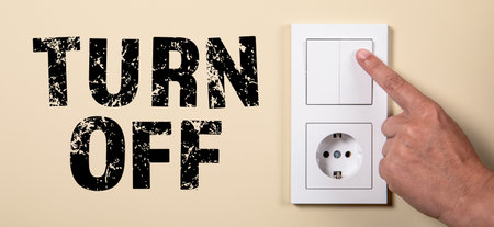 Turn Off. Female hand turning an electricity light switch