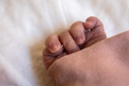 Newborns hand. Small fingers and nails, peeling skinの写真素材