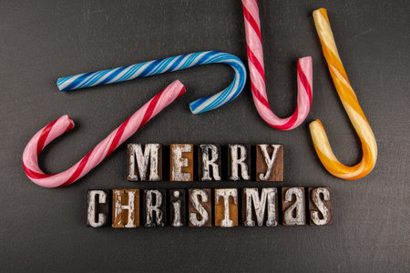 MERRY CHRISTMAS. Text and colorful candies on blackboard backgroundの写真素材