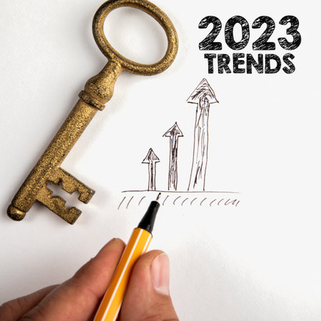 2023 TRENDS concept. Golden key and development arrows on white background