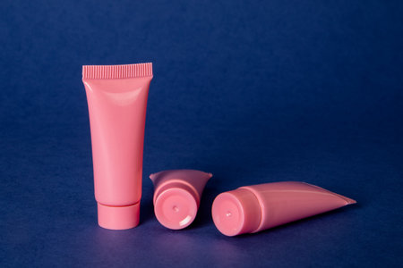 Pink cosmetic tubes on a dark blue backgroundの写真素材