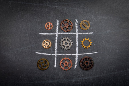 Gears on a dark chalkboard. Game of tic tacの写真素材