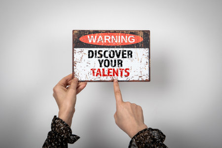 Discover Your Talents. Warning sign with text in the hands of a womanの写真素材