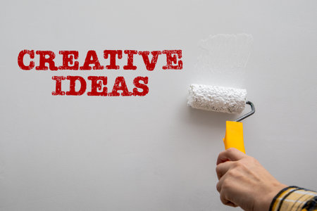 Creative Ideas concept. Paint a white wall with a paint rollerの写真素材