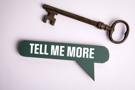 Tell Me More. Speech bubble with text and old key on white backgroundの写真素材