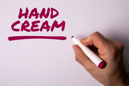 Hand Cream. A hand with a marker writes text on a light backgroundの写真素材
