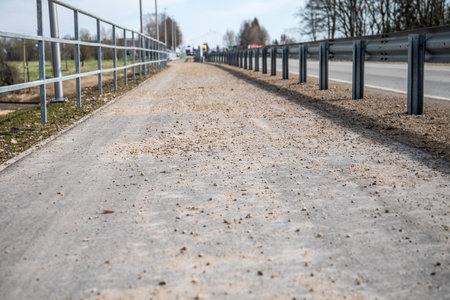 A dirty asphalted pedestrian sidewalk with dust and debris. Sunny warm dayの写真素材