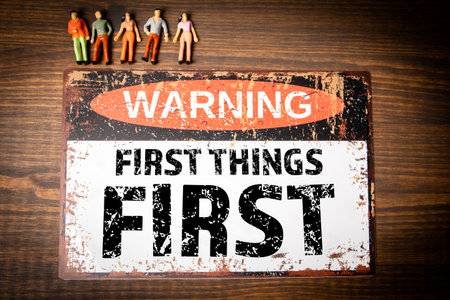 First things first. Warning sign with text on wood texture backgroundの写真素材