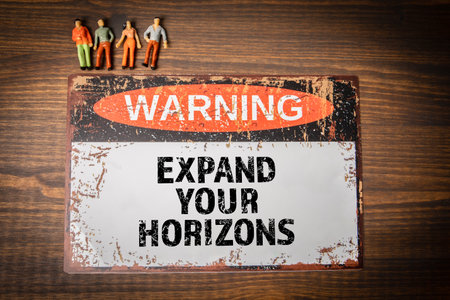 Expand your horizons. Warning sign with text on wood texture backgroundの写真素材