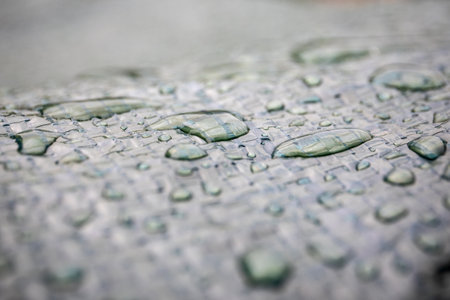 Water drops on a dark awning. Texture and close-up