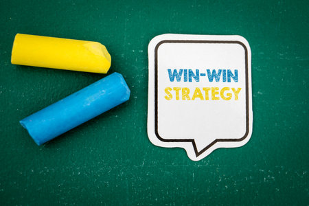 Win-Win Strategy. Speech bubble with text on a green chalkboard background