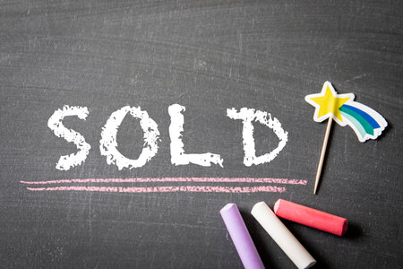 SOLD. Colored pieces of chalk on a dark chalkboard backgroundの写真素材