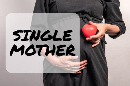 Single Mother. Pregnant woman with a red rubber heart in hand