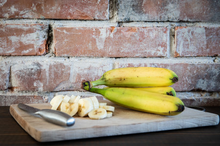 ââBanana on a wooden board. A brick wall in the backgroundの写真素材