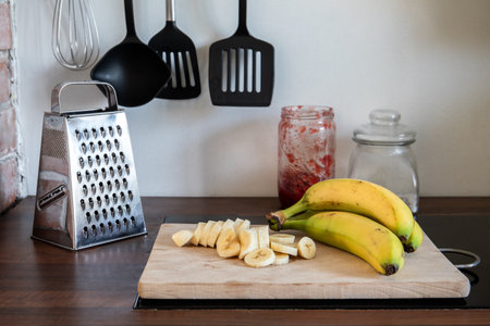 ââBananas on the kitchen table. Various kitchen utensils in the backgroundの写真素材