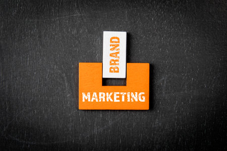 MARKETING and BRAND Concept. Wooden blocks on a blackboard backgroundの写真素材