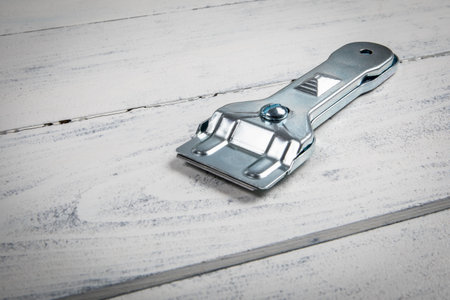 Glass ceramic scraper on a white wooden background