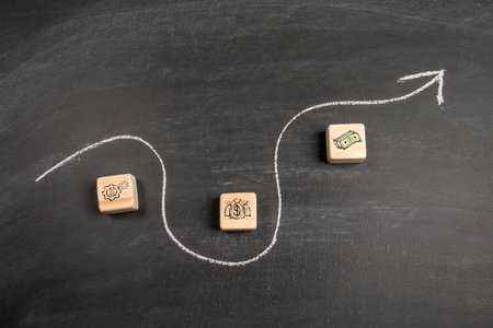 Profit and development. Wooden blocks and arrow on chalkboard background