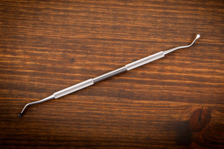 Dentist and dental hygienist instrument on wooden background