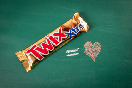 Twix XTRA bars and a drawn heart on a green chalkboard background. Twix bars are produced by Mars Incorporatedのeditorial素材
