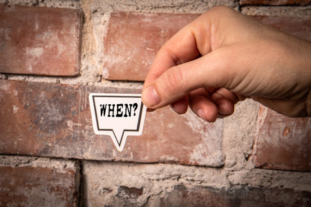 When. Question on a white speech bubble. Red brick backgroundの写真素材