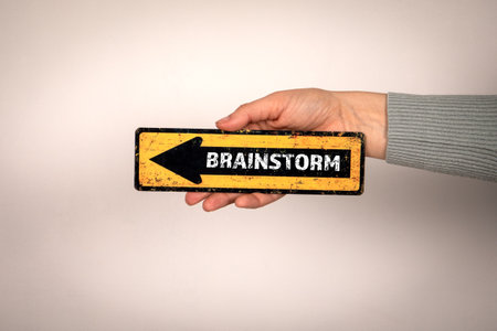 Brainstorm. Arrow with text in womans hand on white backgroundの写真素材