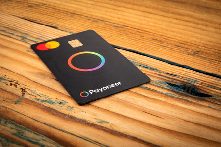 Payment card Payoneer Mastercard on a wooden backgroundのeditorial素材