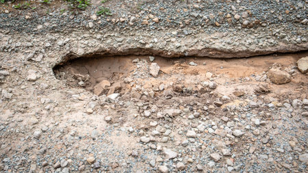 Close-up of washed out road, deterioration of infrastructureの写真素材