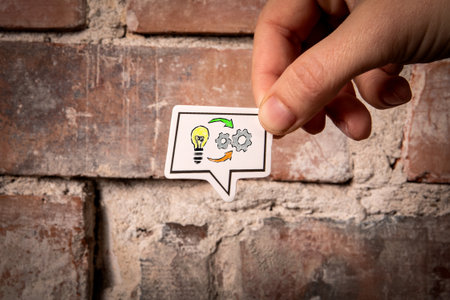 IDEA and SKILL Concept. Speech bubble in hand on red brick background