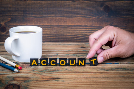 ACCOUNT. Old letter tiles on a wooden texture office tableの写真素材