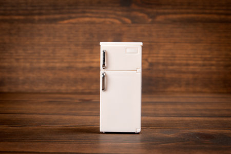 White miniature refrigerator on wooden texture background.の写真素材