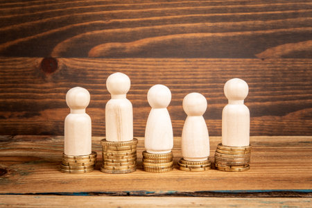 Profit and wage competition. Miniature human figures and money on a wooden texture backgroundの写真素材