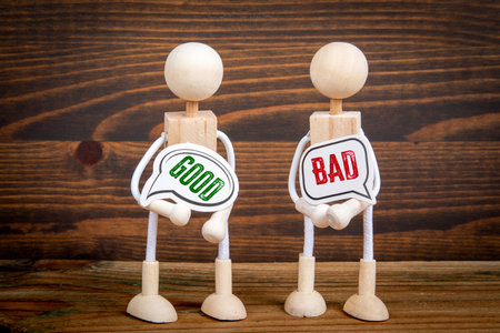 Two speech bubbles and miniature people on a wooden texture backgroundの写真素材