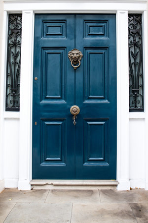 Sophisticated blue building door with lion image on door knocker, architectural design