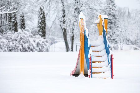 Childrens slide with stairs in the playground covered with a lot of snowの写真素材