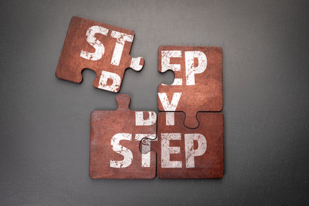 Wooden puzzle pieces with text on a dark office tableの写真素材