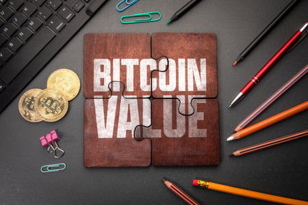 Bitcoin Value. Wooden puzzle pieces with text on a dark office table
