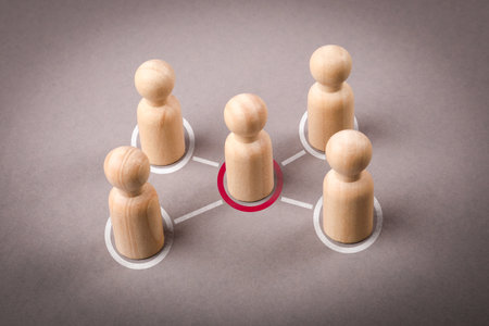 Wooden figures on a gray background. Intermediary between groups Political negotiationsの写真素材