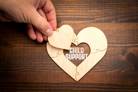 Wooden puzzle in the shape of a heart on a wooden texture background